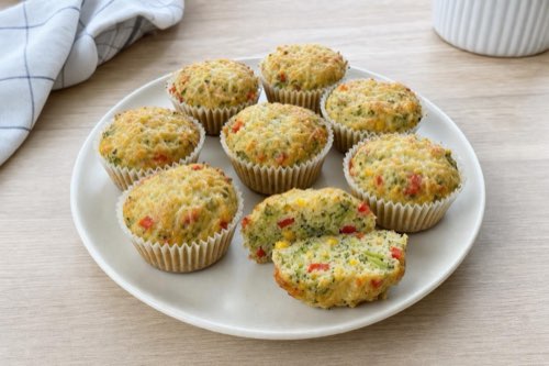 Brokolicové muffiny so syrom, paprikou a kukuricou na tanieri, jeden prekrojený