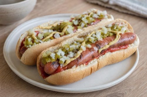 Hotdog s grilovaným párkom, uhorkou a cibuľou