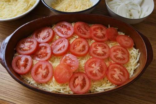 Baked chicken breasts with potatoes, tomato and cheese