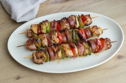 Grilled chicken skewers with bacon and sausage
