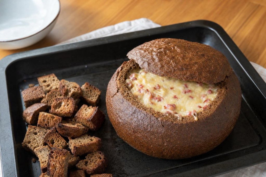 Baked dark bread with bacon and cheese filling